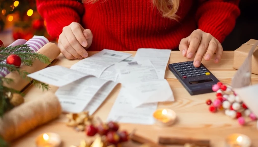 Woman in Christmas sweater looking at bills