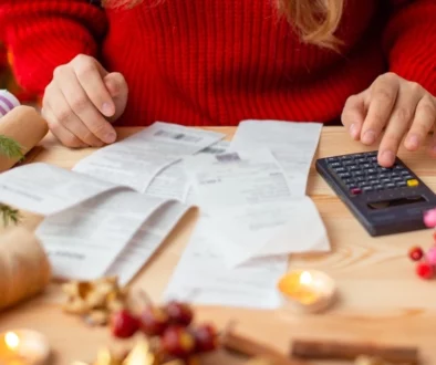 Woman in Christmas sweater looking at bills